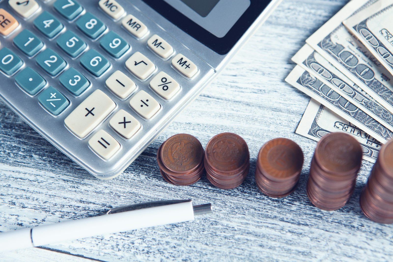 Calculator, pen and money on a table