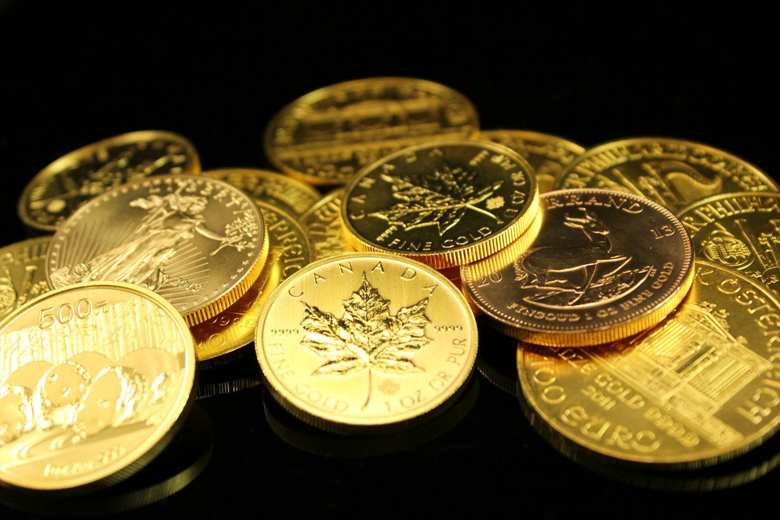Gold Maple Leaf bullion coins on a dark background